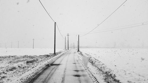 Road amidst snow covered land against sky