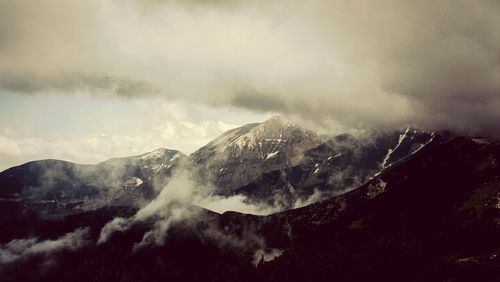 Scenic view of mountains against cloudy sky