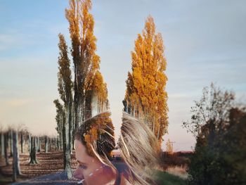 Double exposure  portrait of woman standing against sky and trees during sunset
