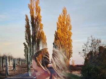 Rear view of woman standing against sky during sunset