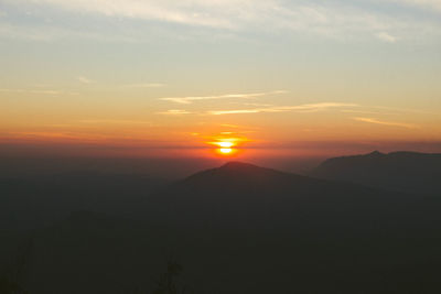 Scenic view of silhouette mountains against sky during sunset