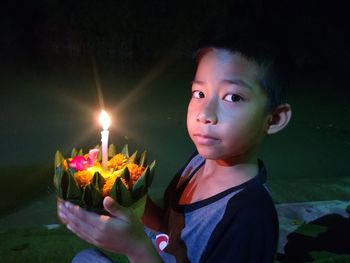 Portrait of cute girl with illuminated candles in background