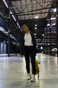 Portrait of businesswoman with backpack standing at railroad station