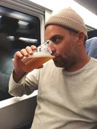 Man drinking beer in train