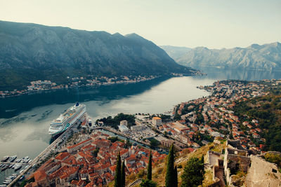 High angle view of cruise ship moored at harbor in city against mountains