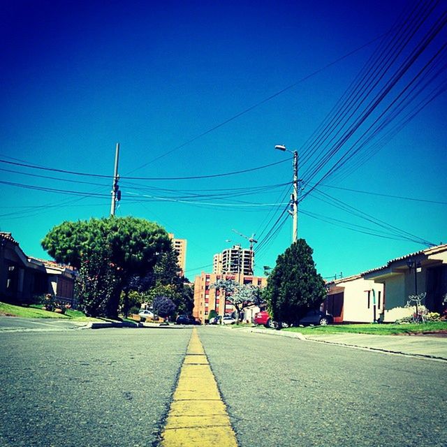 power line, building exterior, architecture, built structure, electricity pylon, the way forward, clear sky, cable, blue, street, electricity, road, city, power supply, sky, power cable, house, street light, diminishing perspective, residential structure