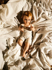 Portrait of cute boy lying on bed