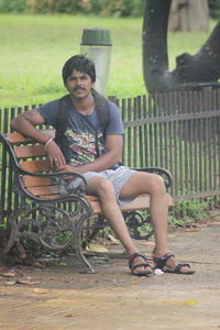 Portrait of young man sitting on bench