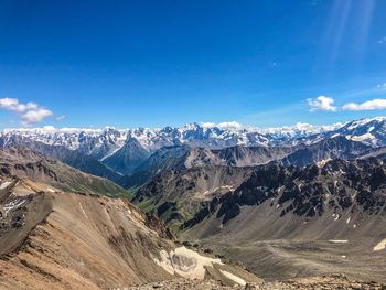 Scenic view of snowcapped mountains against blue sky