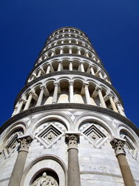 Low angle view of leaning tower of pisa against blue sky