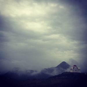 Low angle view of church on mountain against cloudy sky