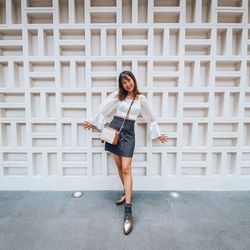 Full length portrait of a smiling young woman
