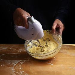 Midsection of man mixing batter with grinder