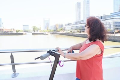 Side view of woman sitting on wheelchair in city