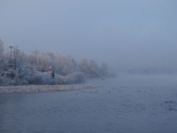 Scenic view of lake against sky during winter