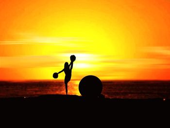 Silhouette people on beach against sky during sunset