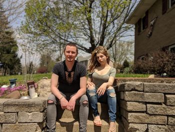 Full length of young couple sitting outdoors