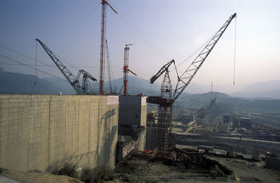 Cranes at construction site against sky