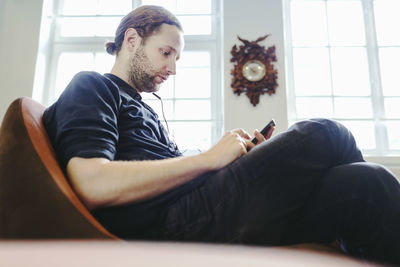 Side view of businessman using smart phone in creative office