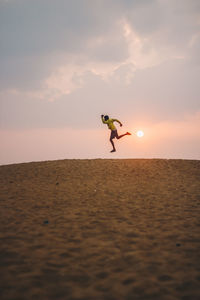 Happy person jumping during sunrise 