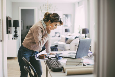 Side view of man using laptop on table