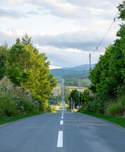 Road amidst trees against sky