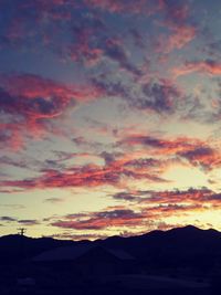Scenic view of dramatic sky over silhouette landscape