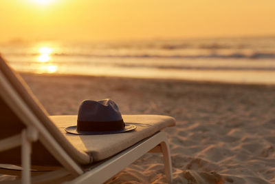 Blue hat is lying on a chaise longue on a beautiful sandy beach 