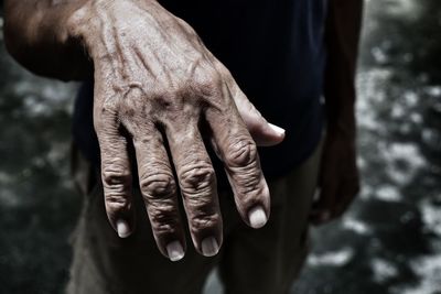 Midsection of man showing wrinkled hand