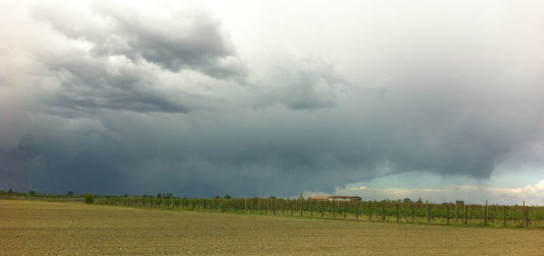 Scenic view of agricultural field against storm clouds