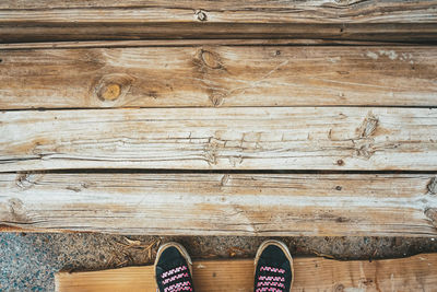 Low section of person standing on wooden floor