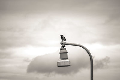 Low angle view of street light against cloudy sky