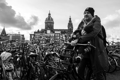 Man standing outside temple against sky in city