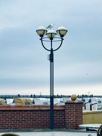 Street light by building against sky