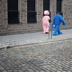 Rear view of women walking on footpath