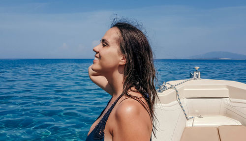 Woman sunbathing on boat at sea.