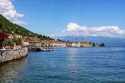 Scenic view of sea by buildings against sky