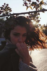 Portrait of young woman against tree