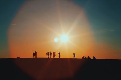 Silhouette people against sky during sunset