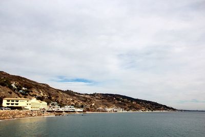 View of townscape against cloudy sky