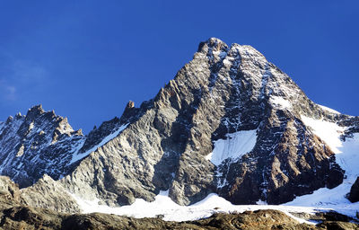 Scenic view of snow covered mountains against clear sky