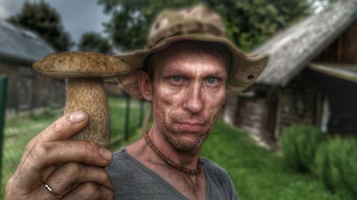 Portrait of man showing mushroom