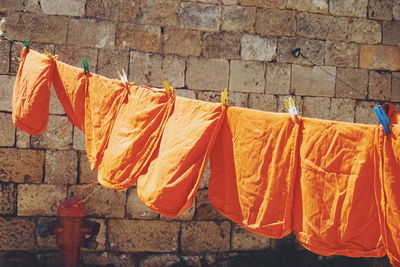 Close-up of clothes drying against orange wall