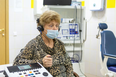 Audiologist checks the hearing of an older woman