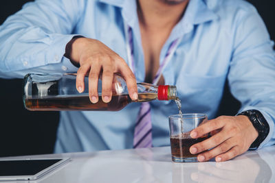 Midsection of man preparing food in glass