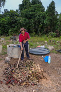 Full length of man sitting on sidewalk in forest