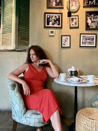 A woman in a red dress sitting with cup of coffee in cafe