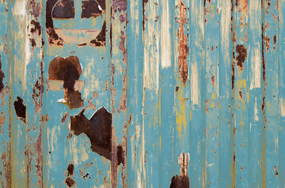 Old rusty metal painted with blue color. empty blue wall texture background. peeling paint on blue 