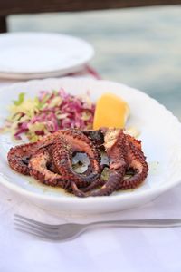 Close-up of whole grilled octopus in plate on table