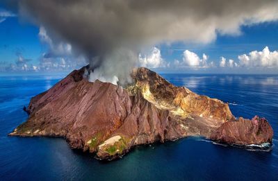 Scenic view of volcano and  sea against sky